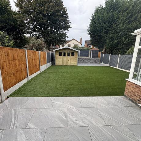 Grey porcelain patio, artificial lawn and new fencing around a garden shed