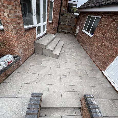 Grey porcelain patio and tiled steps laid between house and garage