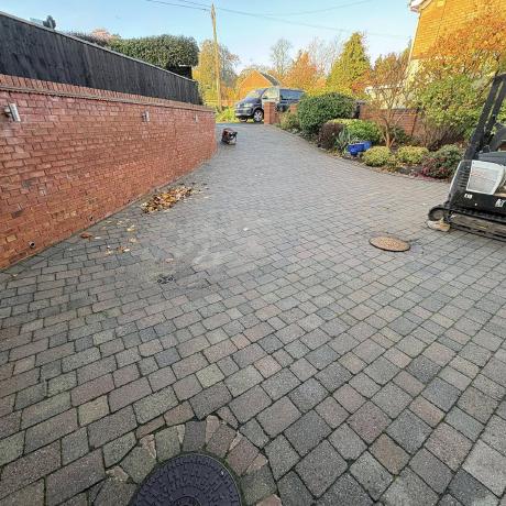 Long block-paved driveway alongside a brick garden wall in the West Midlands