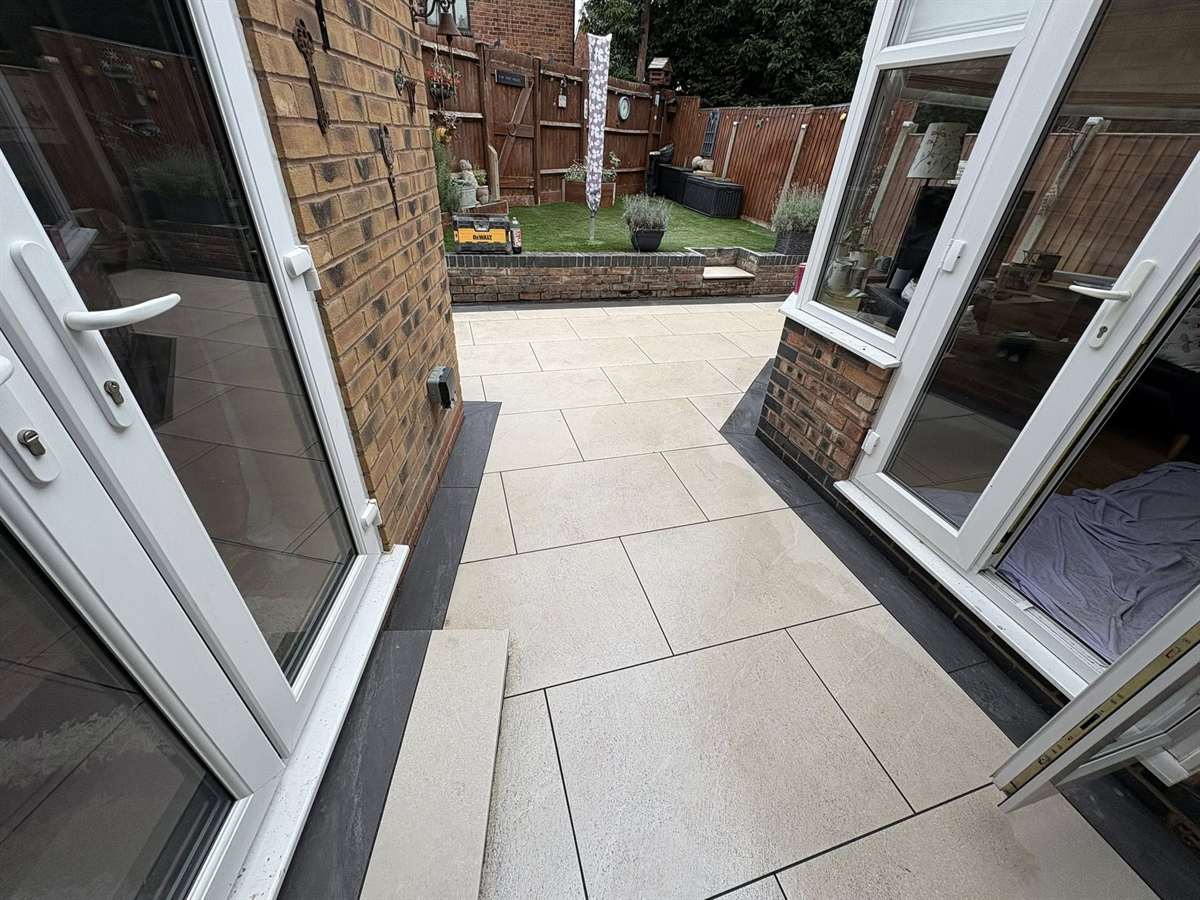 Cream porcelain patio with charcoal border and landscaped garden in the West Midlands